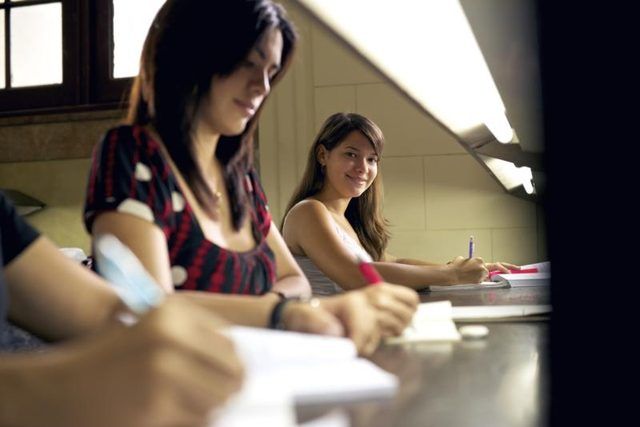 Trois élèves du secondaire de prendre un test à une table.