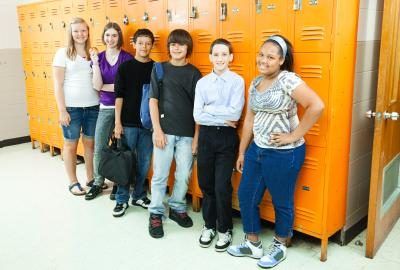 Un groupe de lycéens debout par casiers.
