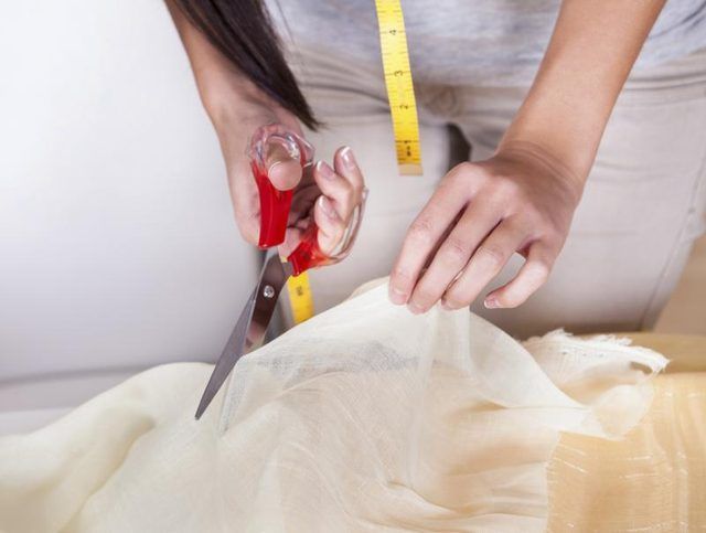 Close-up d'une femme découpant un morceau de tissu.