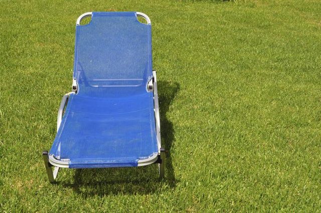 Une chaise longue de jardin portable sur l'herbe.