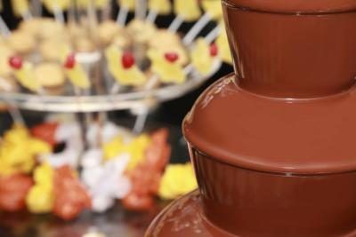 Fontaine de chocolat avec des fruits en arrière-plan