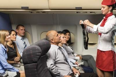 Hôtesse de l'air donnant démonstration ceinture de sécurité à bord des avions