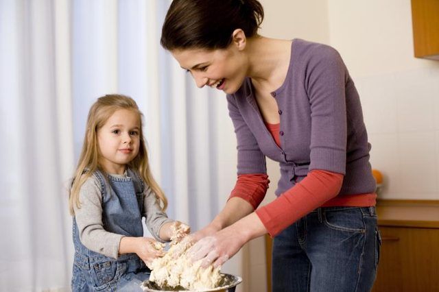 Une mère et son enfant faire de la pâte ensemble.