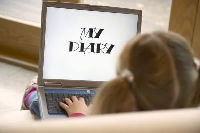 Un enfant écrit dans un journal numérique.