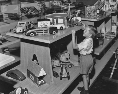 Un petit garçon à l'intérieur d'un magasin de jouets dans les années 1950's