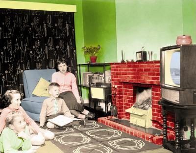Une famille regarde la télévision couleur