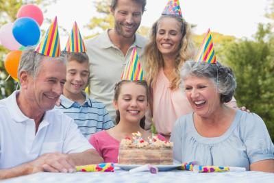 Famille entoure fille avec gâteau d'anniversaire