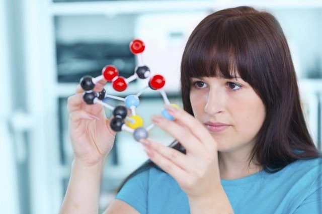 Une adolescente de construire un modèle molécule dans une salle de classe.