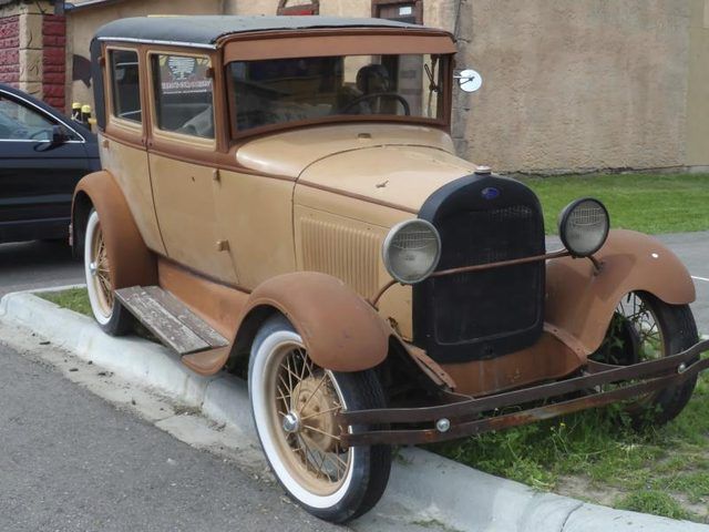 Une voiture Ford Modèle T garée sur un trottoir.