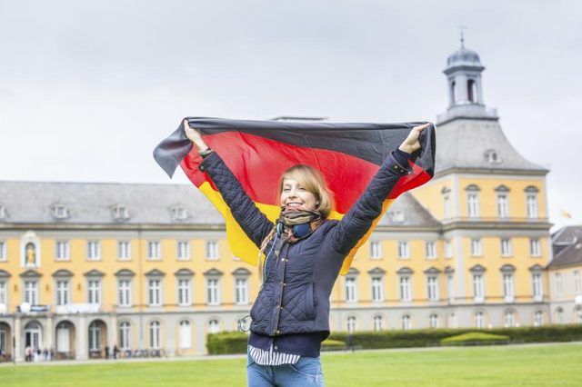 Fille avec un drapeau allemand en face de l'Université de Bonn.