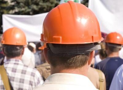 Les membres d'un syndicat portant des casques oranges.