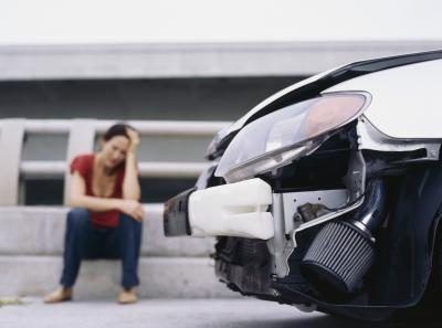 Femme regardant voiture après un accident
