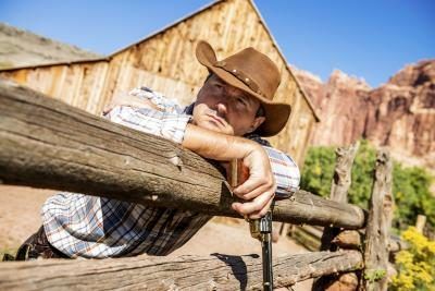 Cowboy avec le pistolet, se penchant sur la clôture