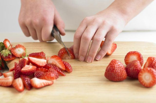 Close-up de la femme de trancher les fraises