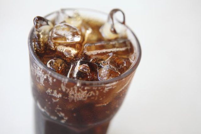 Un grand verre de cola avec de la glace.