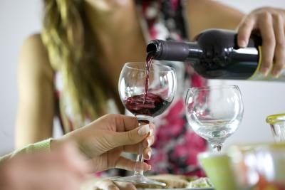 Femme versant un verre de vin
