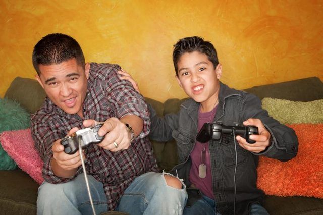 Père et fils jouer à des jeux vidéo.
