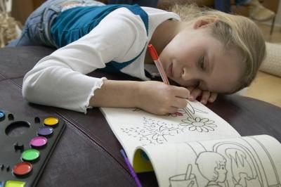 Jeune fille en utilisant livre de coloriage.