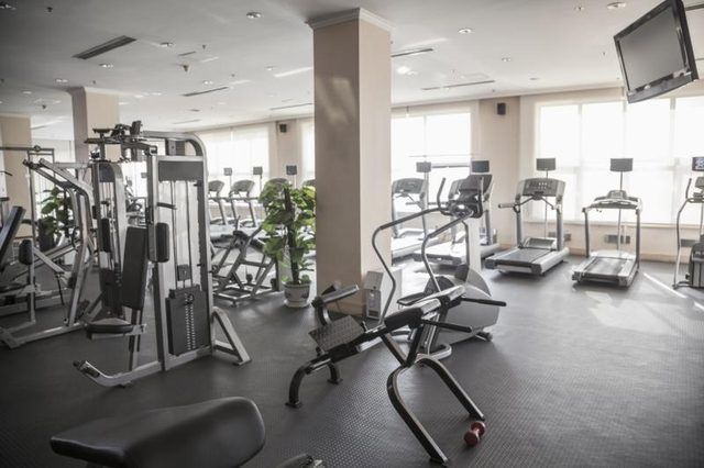 Grande salle de gym avec appareils d'exercice.
