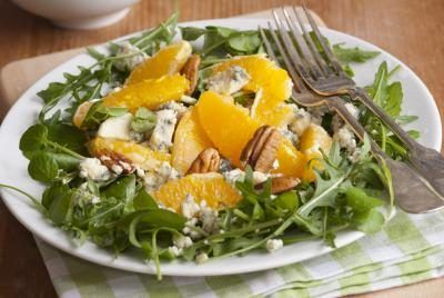 Un gros plan d'une salade d'épinards avec mandarines.