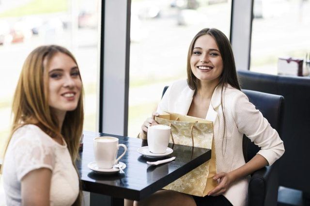Deux femmes ayant un café ensemble dans un café.