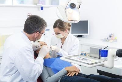 Un travail d'assistante dentaire avec un dentiste pour examiner le patient.