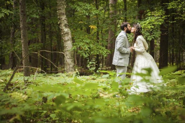 Mariée et le marié embrassant dans les bois.