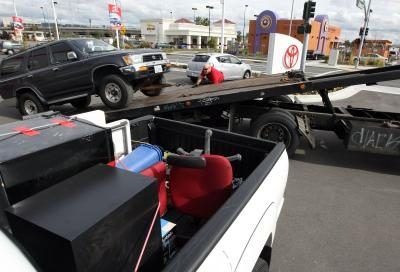 Un chauffeur de camion de remorquage charge une Toyota 4 Runner sur son camion à Oakland en Californie.