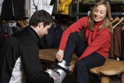vendeur de chaussures femme aider démarrage sur la botte de neige