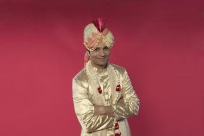 Le marié indienne est rasé de près, vêtu royalement dans les tissus riches et orné de guirlandes de fleurs.