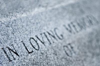 Une inscription de la pierre tombale aide pour commémorer un être cher.