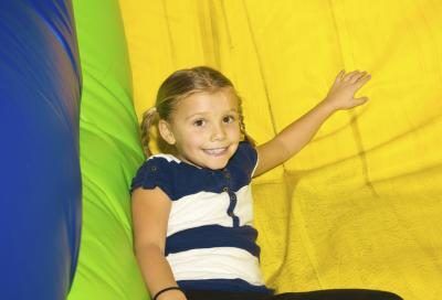 Enfant souriant sur grand toboggan gonflable