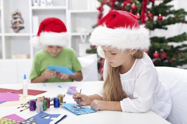 Deux enfants font des cartes de vœux pendant le temps de Noël.