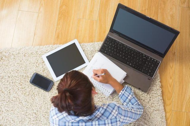 Étudiant travaillant sur essai, prenant des notes