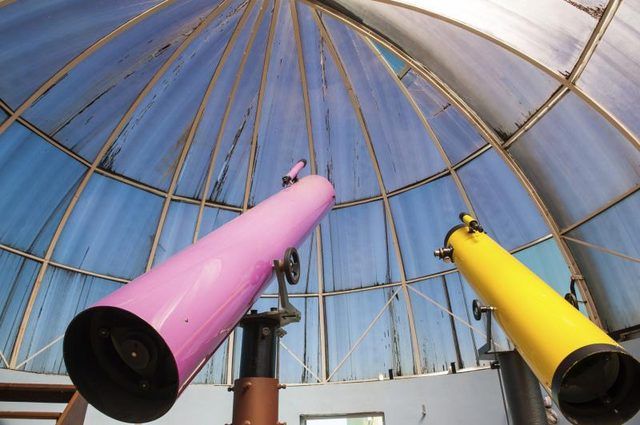 Télescope rose et jaune dans un observatoire.