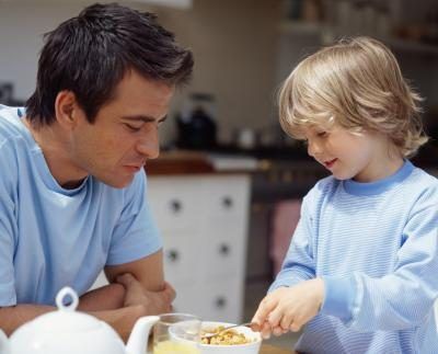 Un père et son fils préparent un bol de céréales ensemble le matin.