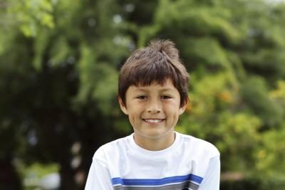 Un jeune garçon souriant avec des fossettes.
