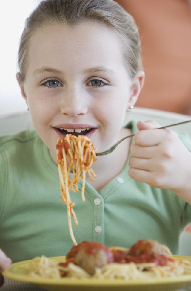 Fille de manger spaghettis aux boulettes