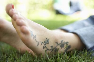 Tatoué pieds nus dans l'herbe.