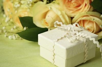 Petit cadeau de mariage enveloppé côté bouquet de fleurs.