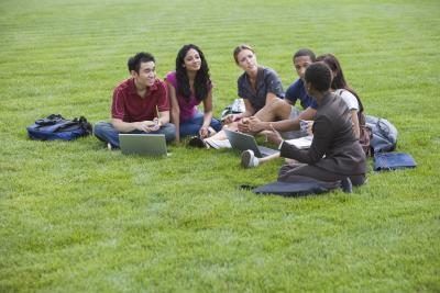 Les étudiants avec un professeur sur une pelouse du campus