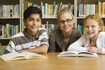 enseignant avec deux jeunes étudiants dans la bibliothèque