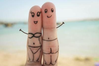Encre sur deux doigts dépeint un couple heureux sur la plage.