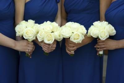 Demoiselles d'honneur en robe bleue tenant des bouquets de fleurs jaunes