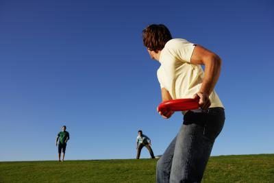 Les personnes jouant au frisbee sur un terrain herbeux.