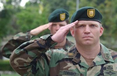 Officiers des forces spéciales américaines saluent pendant l'hymne américain.