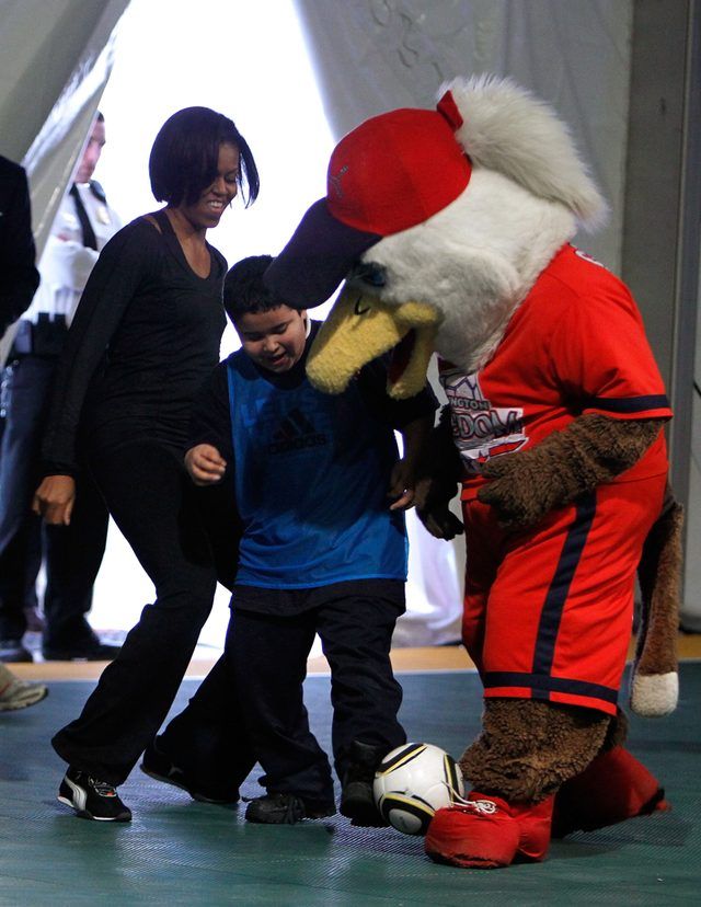 Première Dame Michelle Obama, étudiant et Eagle balle mascotte coup de soccer autour