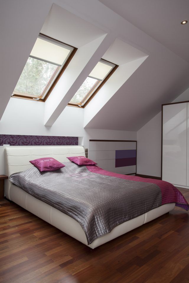Une chambre moderne avec des draps et des oreillers gris lilas.