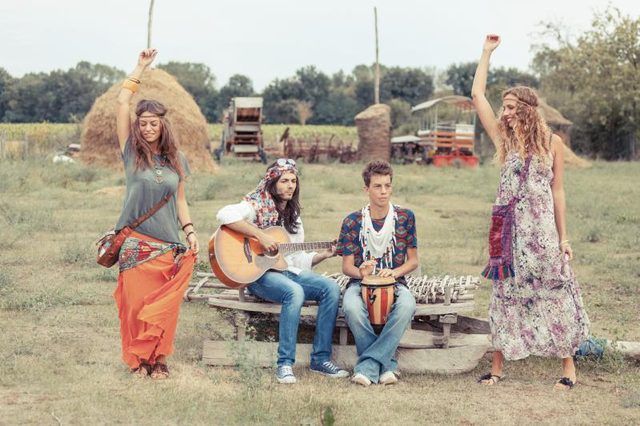 Hippies danser et jouer de la musique dans un champ.