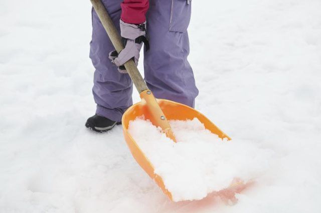 Close-up d'une adolescente de pelleter la neige
